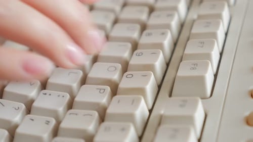 Business woman typing on old style keyboard keys close-up slow tilting 4K 2160p UltraHD footage -