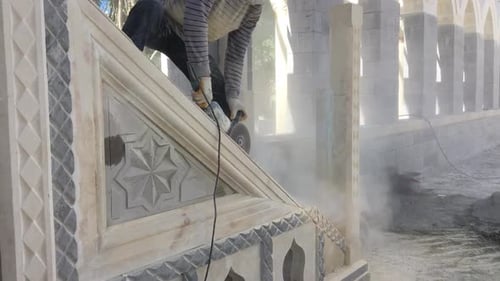 Adult Cutting Stone With a Power Tool
