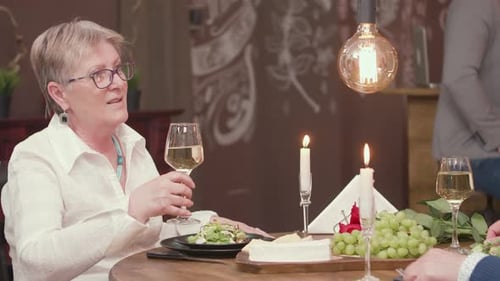 Woman Enjoying Dinner with Wine and Candles