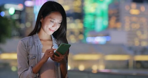 Woman using mobile phone at night