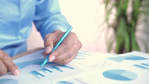 Young Man Working on Office Desk Analyzing Financial Data