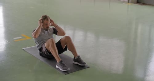 Jeune homme adulte faisant de l'exercice situps pendant l'entraînement sportif de remise en forme
