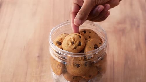 Hand Selecting Chocolate Chip Cookies From Jar