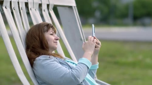 Woman Relaxing Using Mobile Phone in City