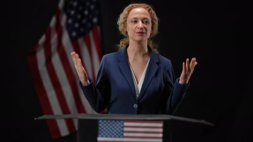 Woman Gives Speech Behind Podium with American Flag
