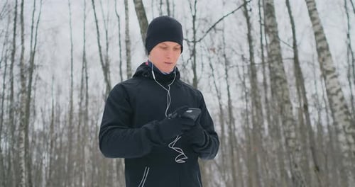 A Young Man in a Black Hammer in the Winter Is Preparing To Jog in the Park Includes an Application