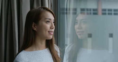 Woman look at the view and stand beside window