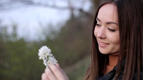 Young Woman Holding White Blossoms Outdoors