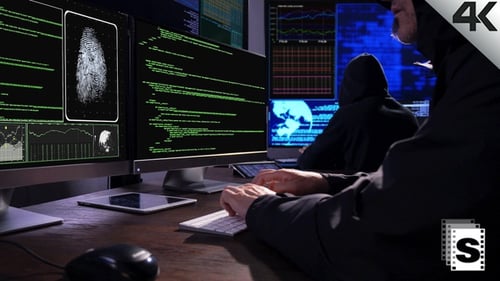 Hooded Hackers Typing Code at Computers