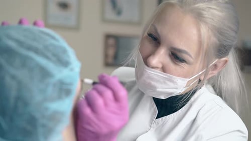 Master in Mask Makes Brows Tattooing on Woman Face in Clinic