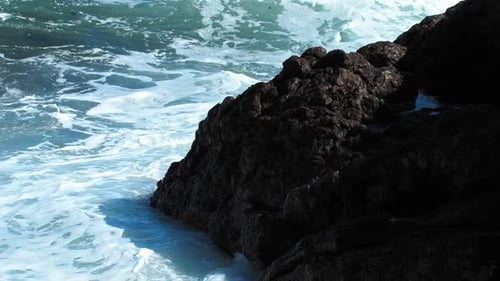 Blue Sea Waves Crash Against Rocks