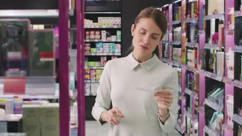 Woman Smelling Perfume Tester in Bright Store
