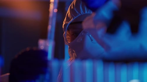 Scientist Analyzes Test Tube in Dark Lab