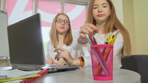Deux adolescentes étudient ensemble à l'aide d'un ordinateur portable