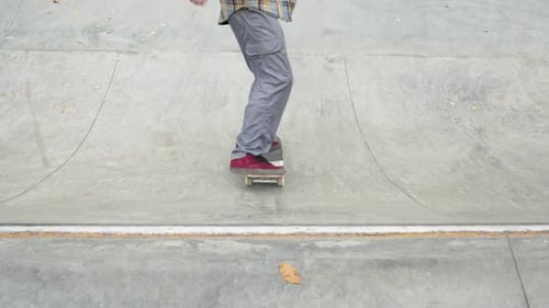 Skater Practicing in the Autumn Concrete Skate Park Making Tricks and Rides in Ramp