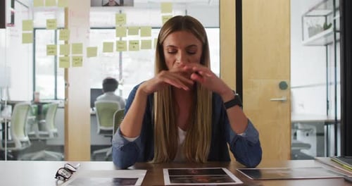 Caucasian businesswoman sitting at desk talking and gesturing during video call in office