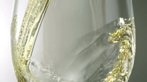 Golden Liquid Pouring into Glass with Bubbles