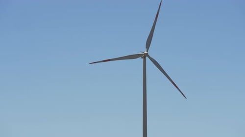 A Spinning Windmill Against Blue Sky