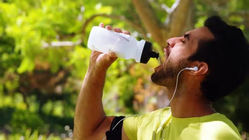 Man Drinks Water in the Park
