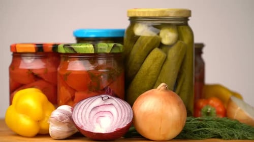 Tarros de vidrio con verduras saladas para el invierno girados sobre la mesa