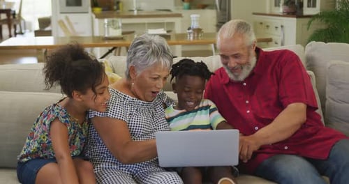 Happy Family Gathers, Using Laptop on Sofa