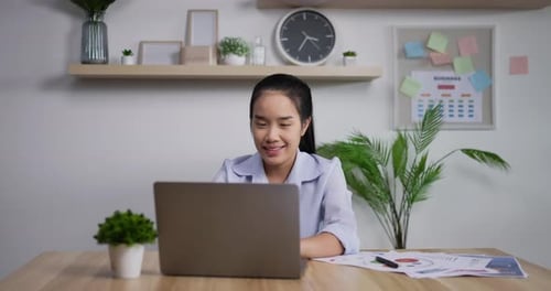 Portrait of Happy asian businesswoman with laptop computer working at home office