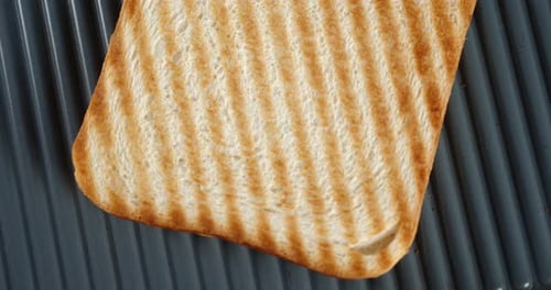 A Piece of Fried Bread Rotates Slowly. On a Black Background. Top View.