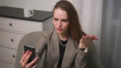 Woman Talking on Phone During a Video Call