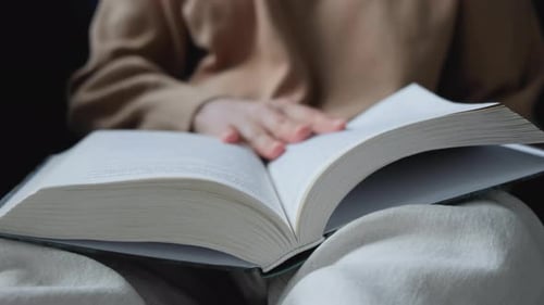 Nahaufnahme einer jungen Inderin, die ein Buch liest und die Seite umblätterte