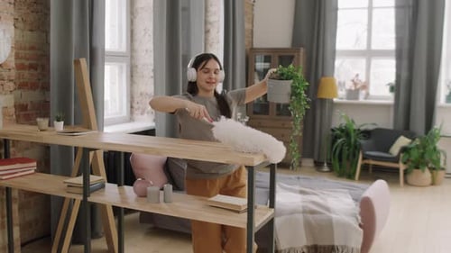 Young Woman Joyfully Dusting with Feather Duster
