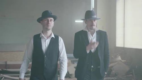 Portrait of Two Smoking Gangsters Walking in the Old Dilapidated Building. Abandoned Dilapidated