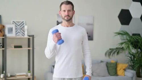 Close Up of Man Working Out with Dumbbells at Home