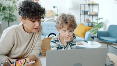 Woman and Child Look at Laptop Together