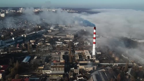 Aerial drone view of industrial smoke coming from pipe factory tube. City pollution idea