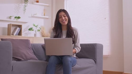 Smiling Woman Using Laptop Computer at Home