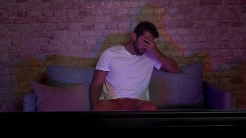 Young Adult Male Reacting to Television at Home