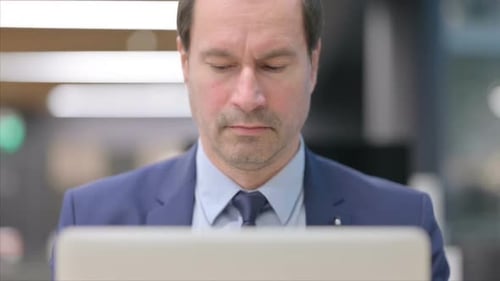 Man Works on Laptop in Office Close Up