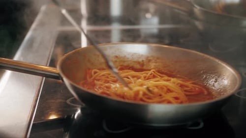 Spaghetti Tossed with Fork in Frying Pan