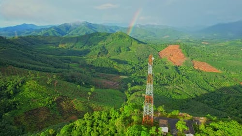 Aerial view over telecommunication towers on green mountain