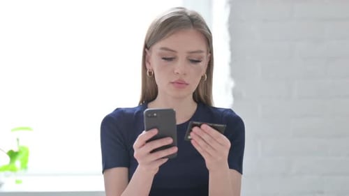 Young Woman Using Phone and Credit Card