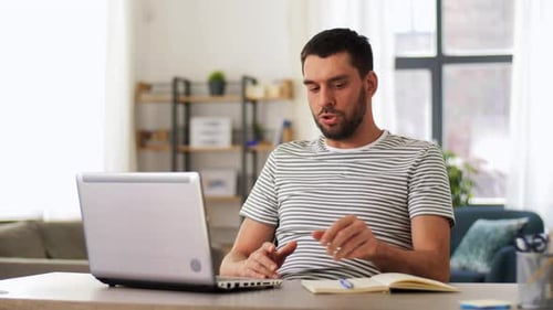 Man Talking on Laptop Video Call in Home Office