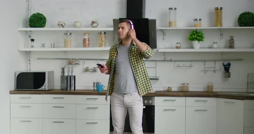 Man Listening to Music and Dancing in Kitchen