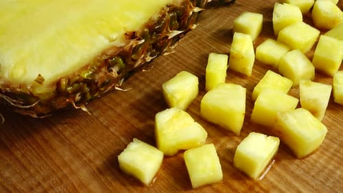 Ripe Pineapple Slices and Cubes on Wooden Board
