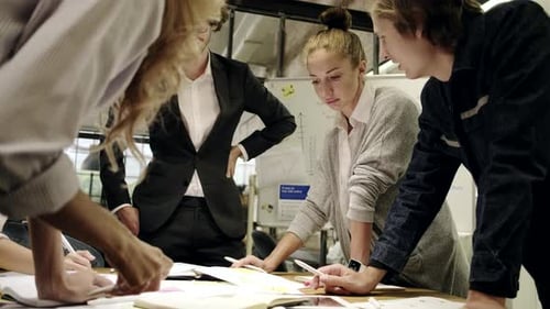 Professionals Collaborate Around Table in Creative Workplace