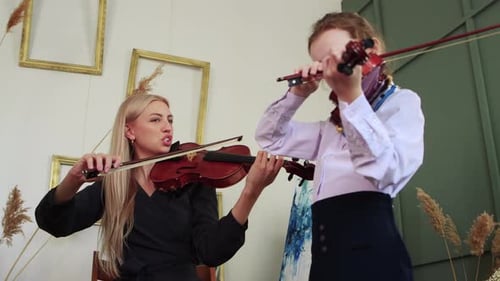 Violin Teacher and Child Practice Music Together Indoors