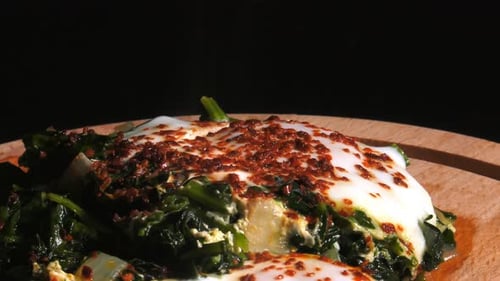 Spinach and Eggs on a Wooden Plate