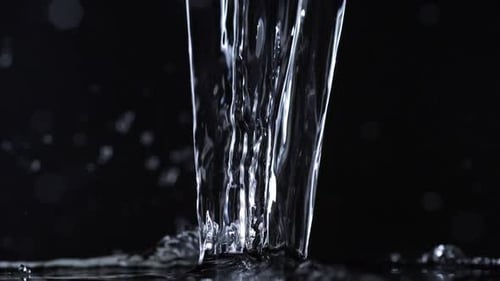 Wasser auf schwarzem Hintergrund gießen, Zeitlupe