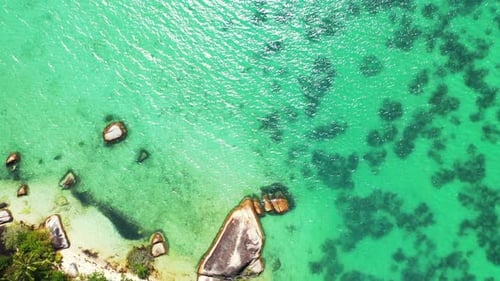 Beautiful birds eye travel shot of a white sandy paradise beach and blue sea background in 4K