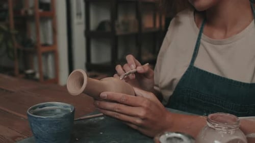 Woman Shaping a Clay Vase in Pottery Studio