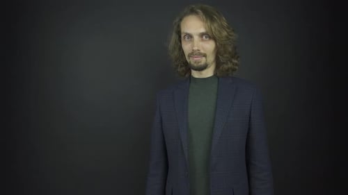 Man with Long Hair in Front of Dark Background